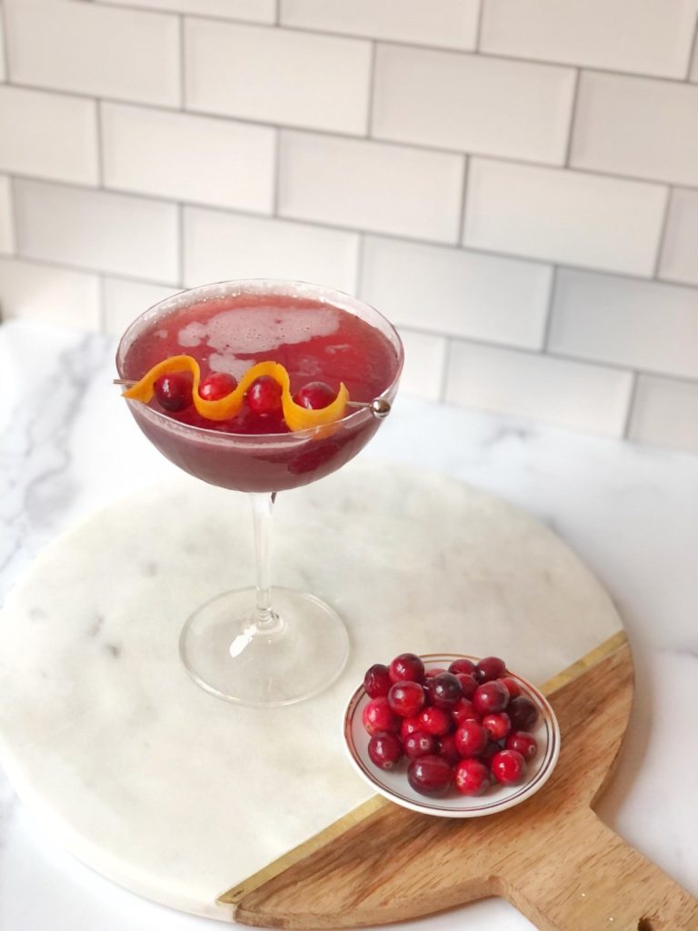 Berry Juniper Fizz mocktail next to a bowl of cherries