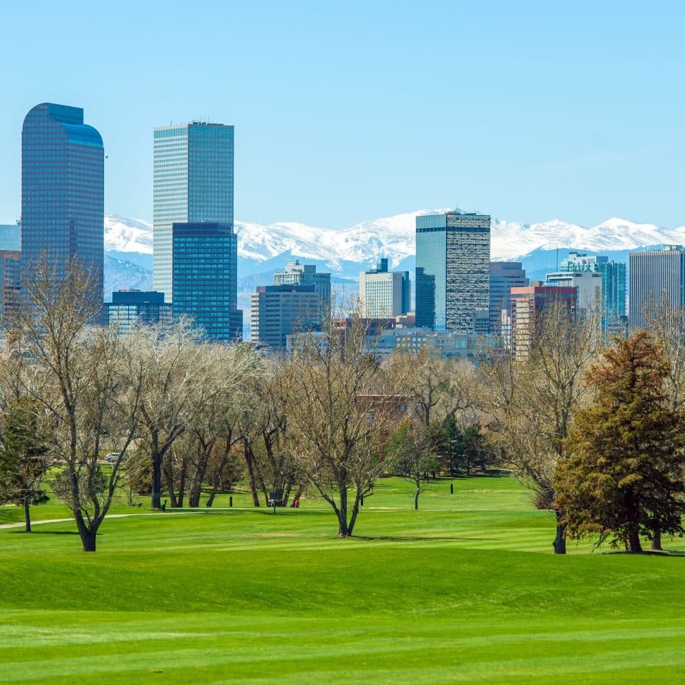 Sunny Denver Skyline. Spring in Colorado. Denver Skyline and Snowy Rocky Mountains.