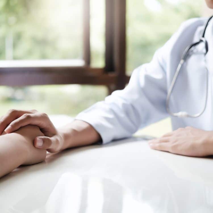 Doctor comforting patient at consulting room.